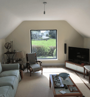 Interior after painting photo of a converted attic living room revamp and paint.