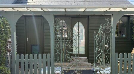 External green cottage shed extension with wood and metal fencing - after image.