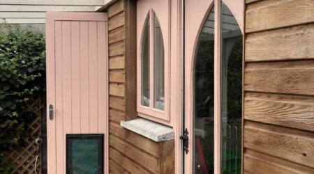 External baby pink and natural wood cottage shed extension with wood and metal fencing - before image.