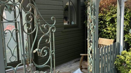 External green cottage shed extension with wood and metal fencing - after image.