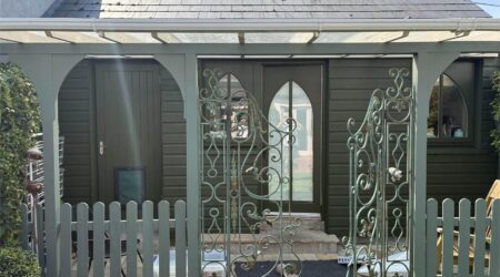 External green cottage shed extension with wood and metal fencing - after image.